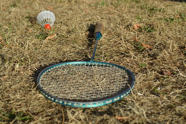 badmintonová raketa s míčkem v trávě